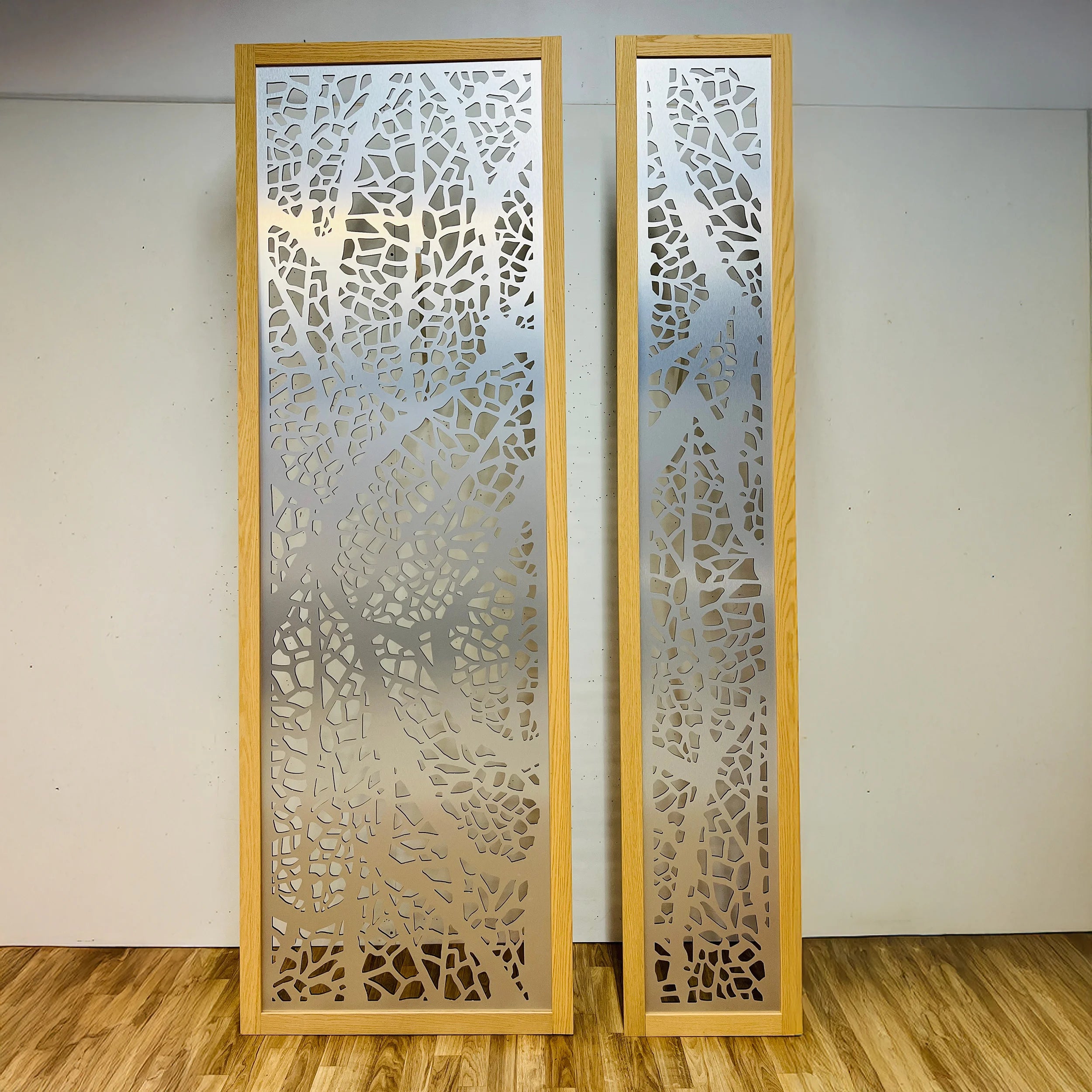 Two decorative panels with intricate cut-out patterns on a plain wall.