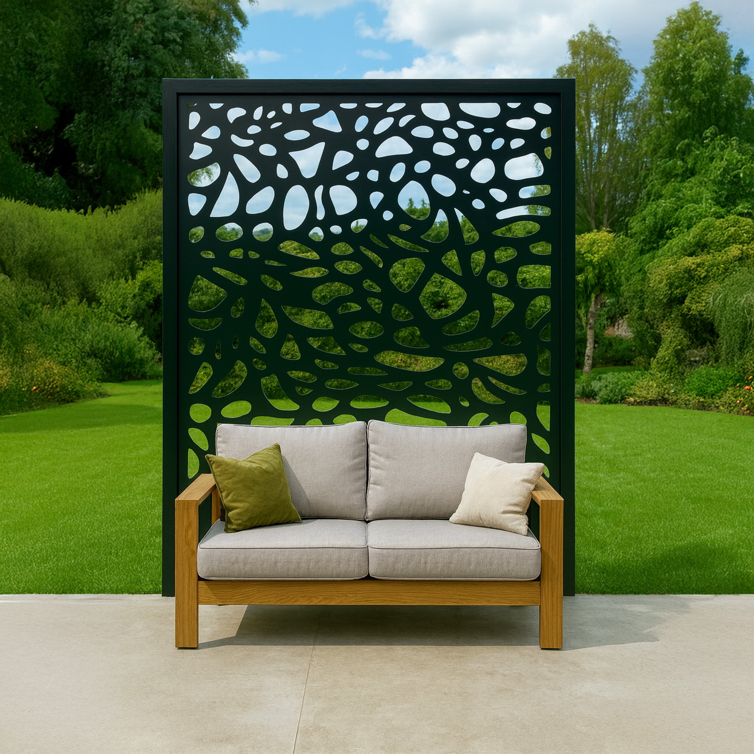 Wooden sofa with gray cushions and a green pillow against a decorative garden screen.