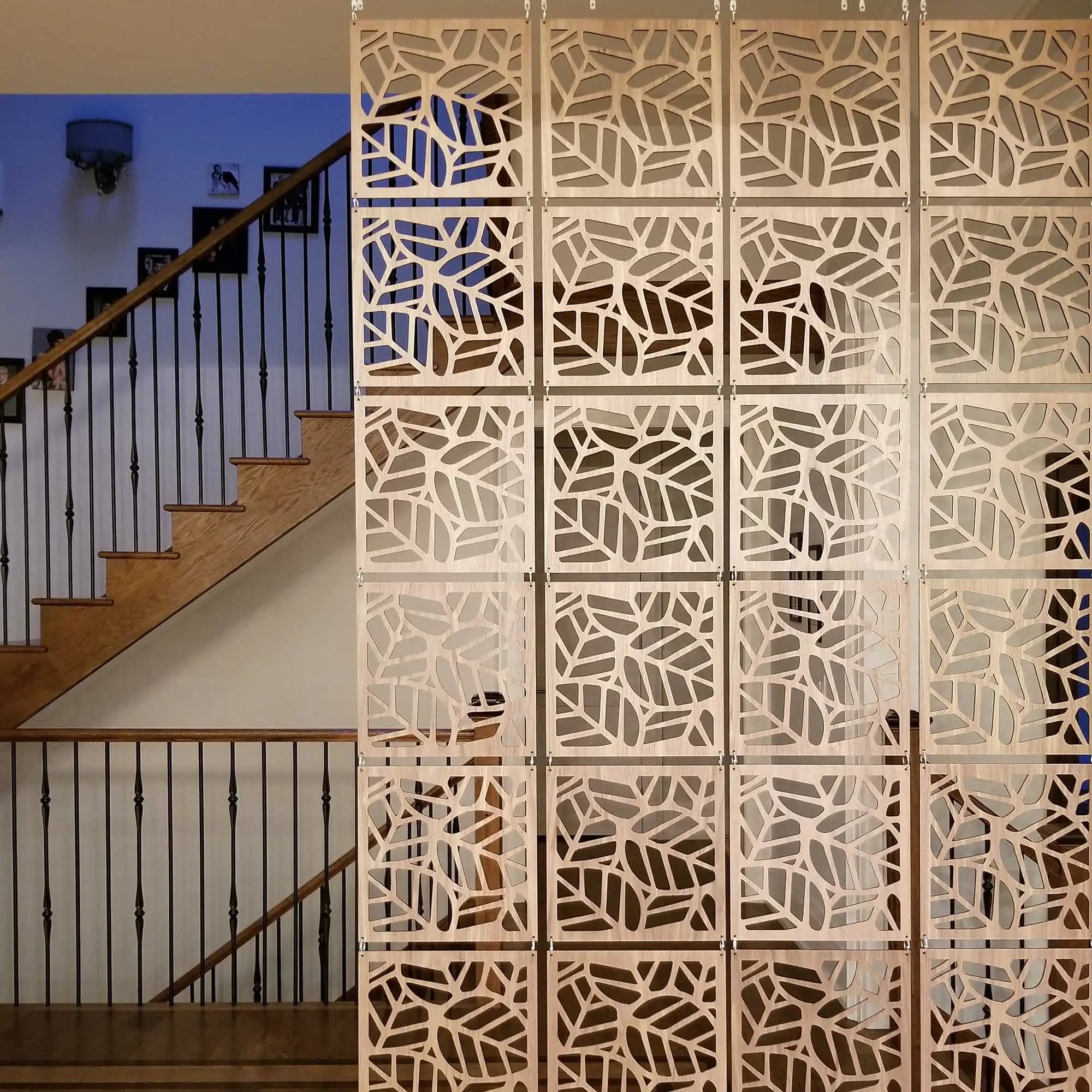 Decorative wooden screen with geometric pattern in a room with stairs.