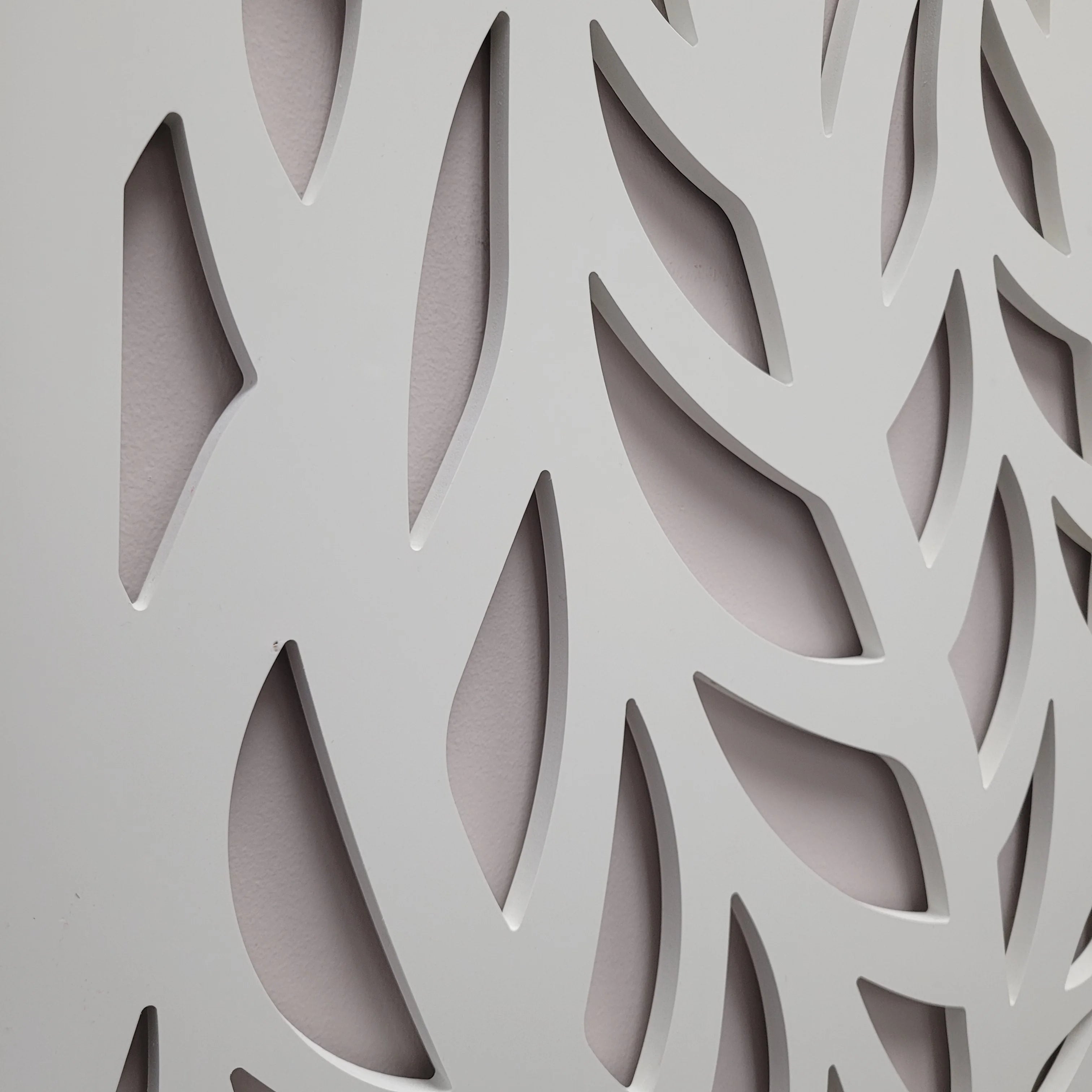 Close-up of a decorative panel with cut-out patterns on a gray background