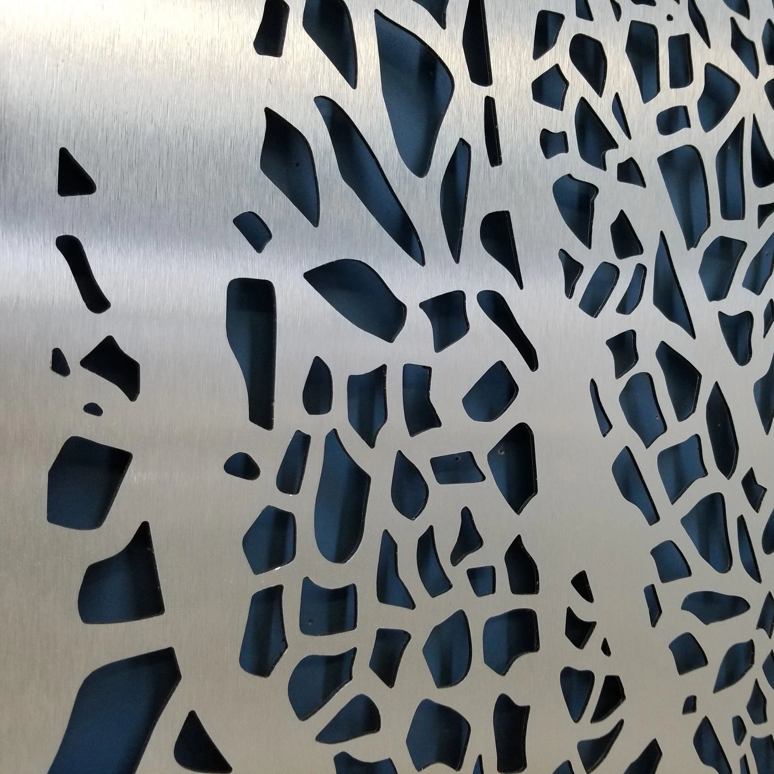 Metallic surface of privacy panel with a geometric cut-out pattern