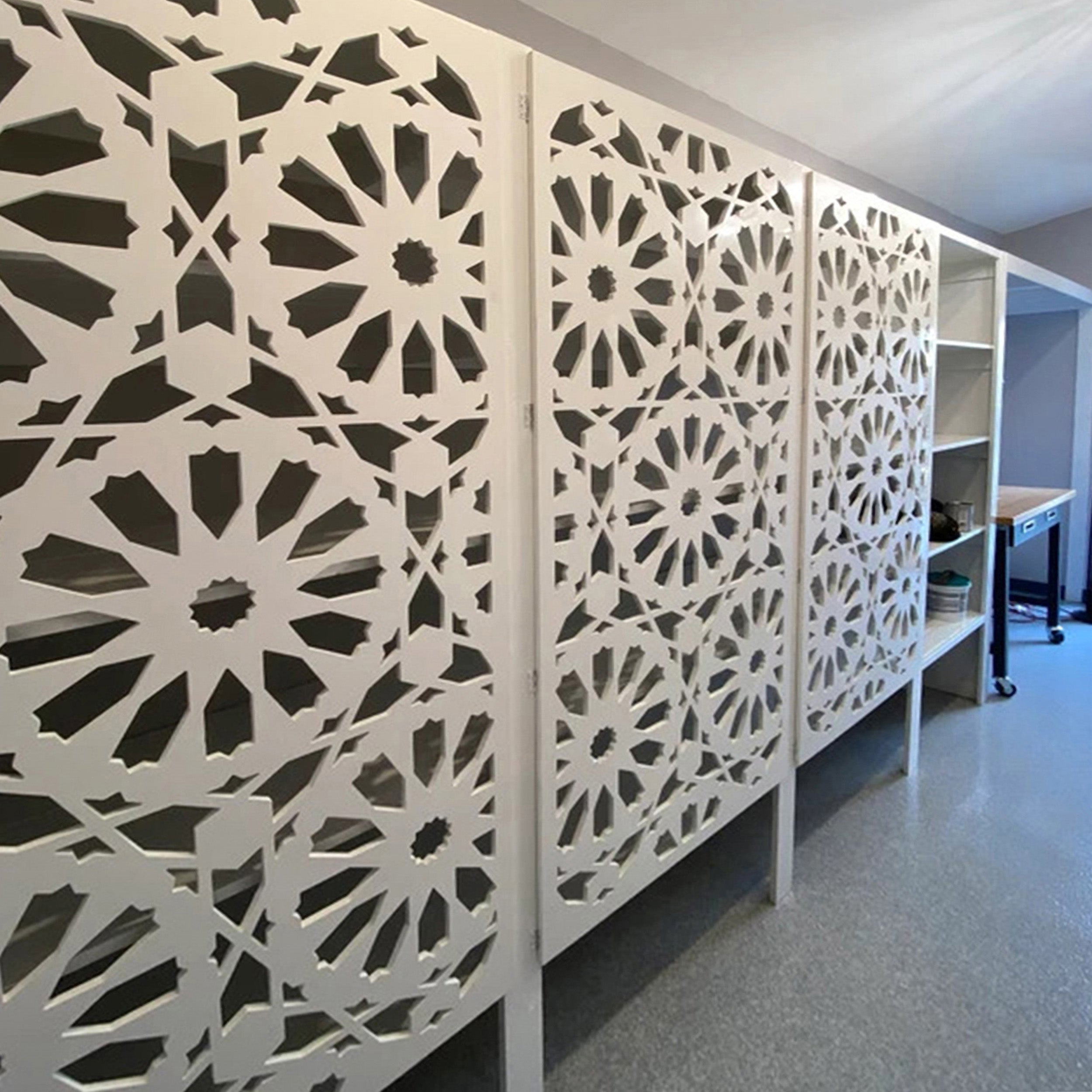 Decorative privacy panels with geometric patterns in an indoor setting.