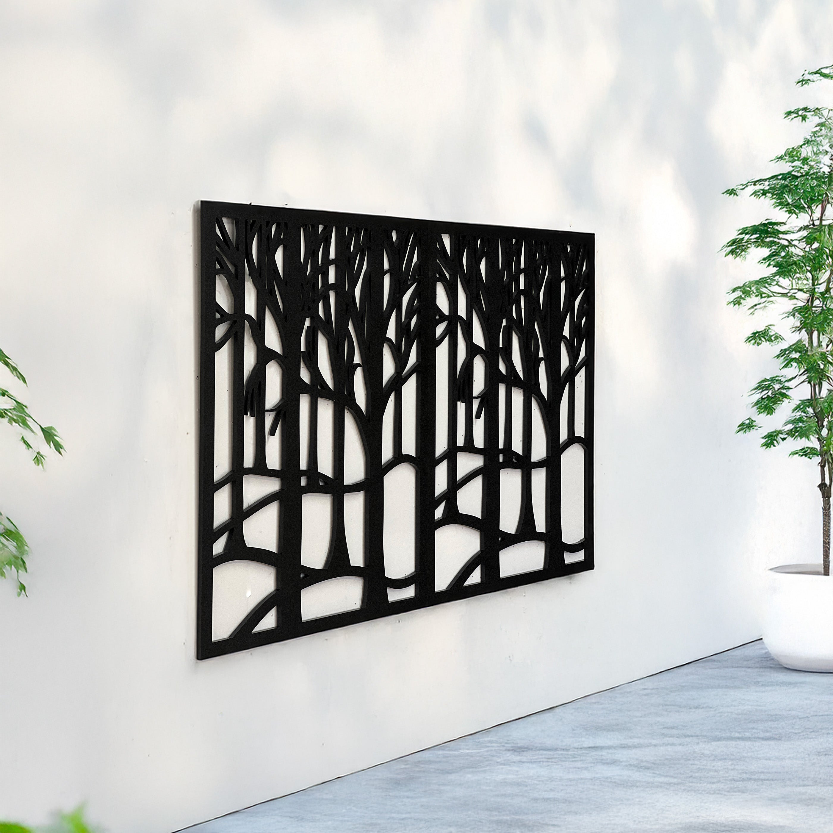 Decorative metal wall art with tree design on a white wall.