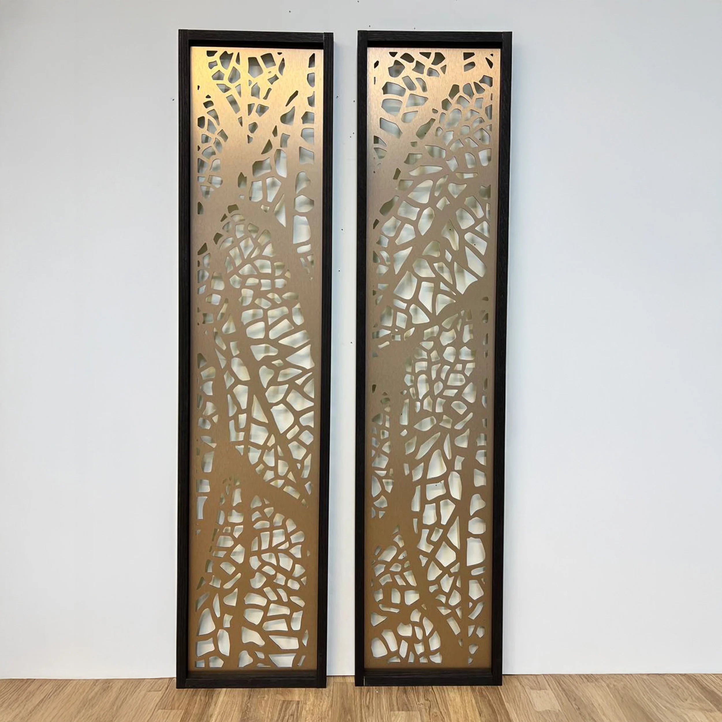 Two decorative wall panels with intricate cut-out patterns on a plain background