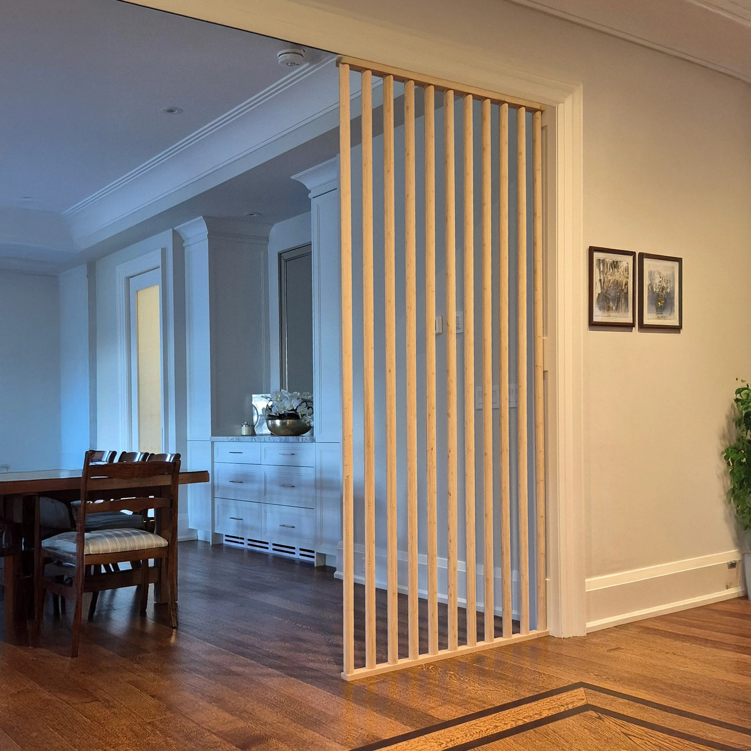 Wooden slatted room divider in a living room setting with furniture and decor.