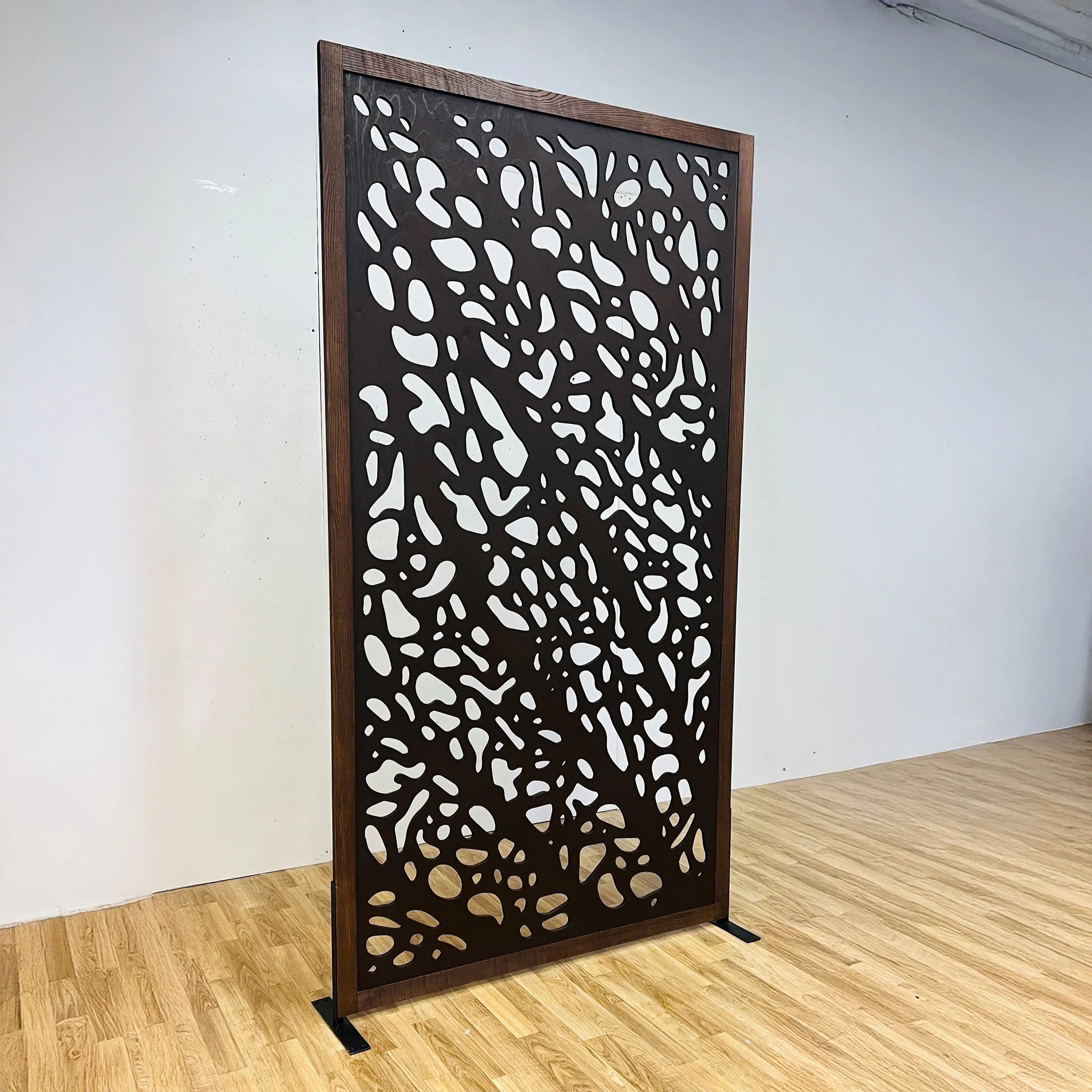 Decorative screen with a unique pattern in a room with wooden floor and white walls