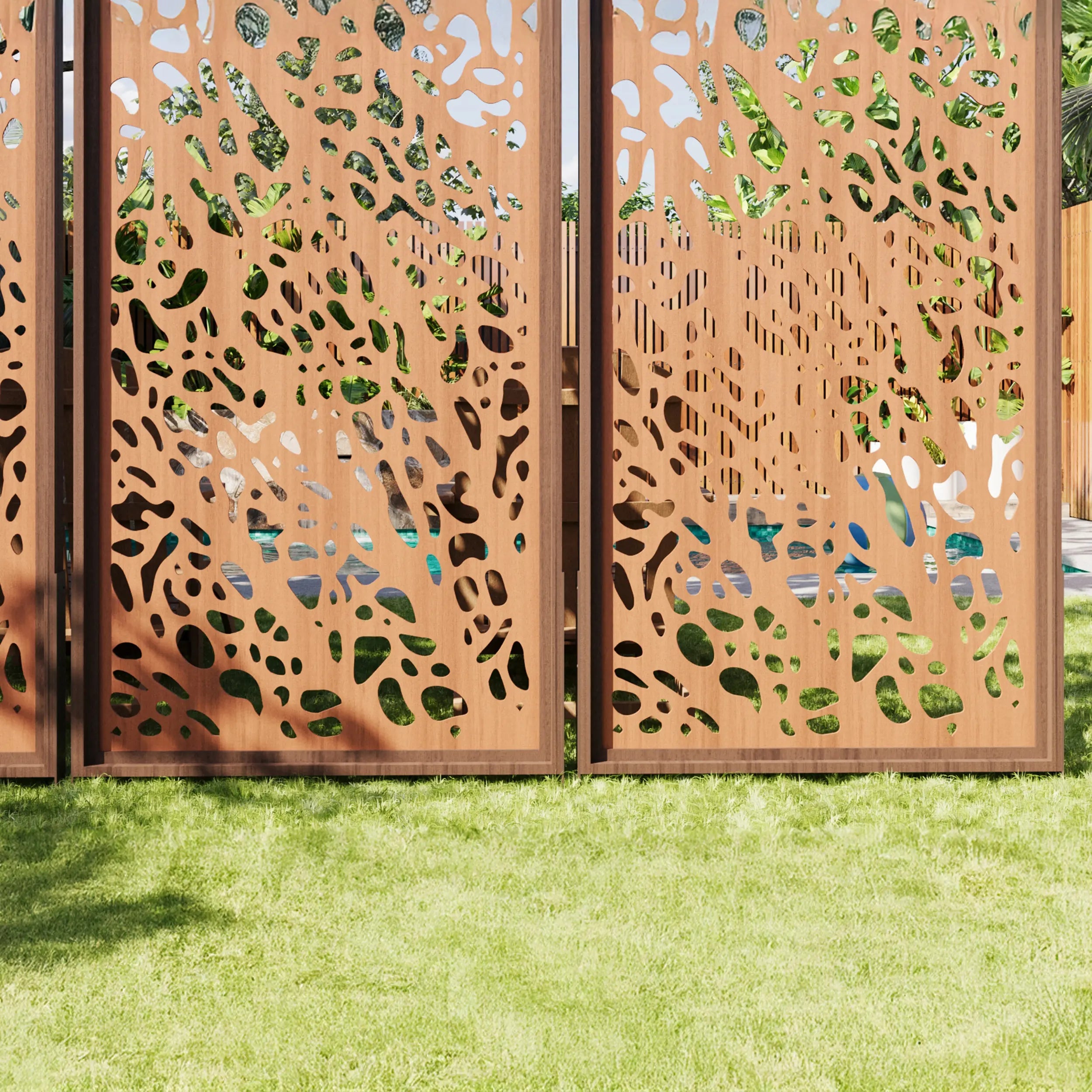 Decorative metal screen with cut-out patterns on a grassy background