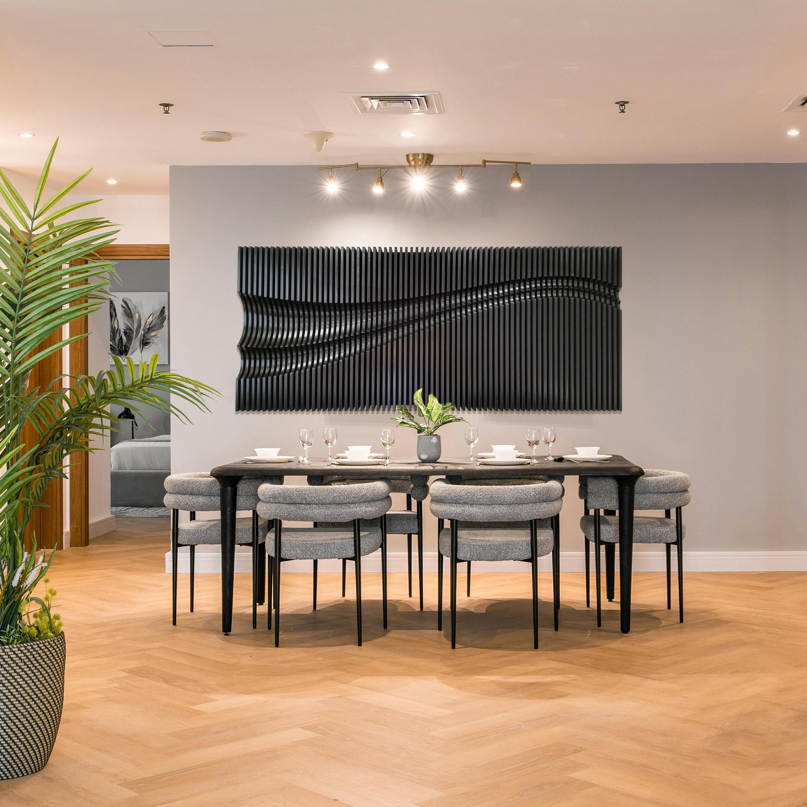 3D abstract fluid art wall panel in a commercial setting with wooden flooring and a dining table with chairs in the foreground.