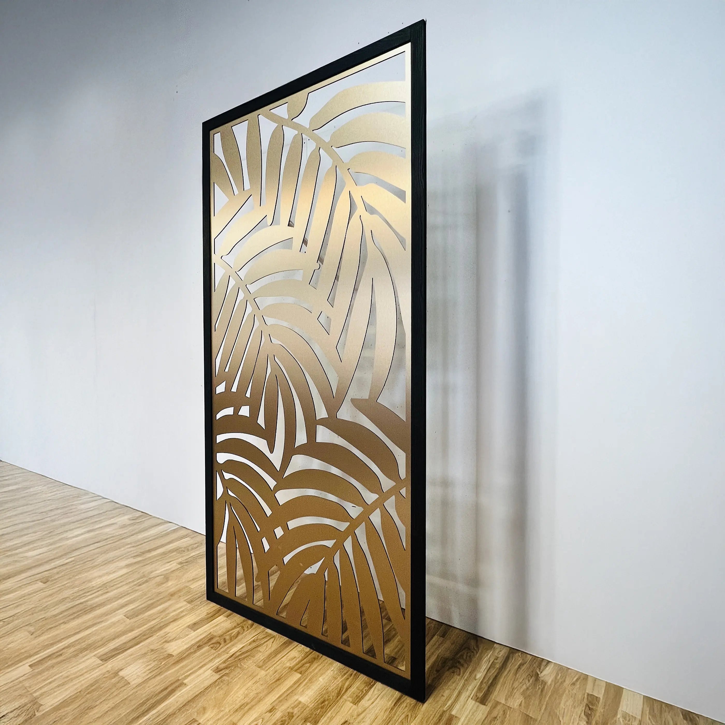 Decorative screen with leaf pattern in a room with wooden flooring and white walls