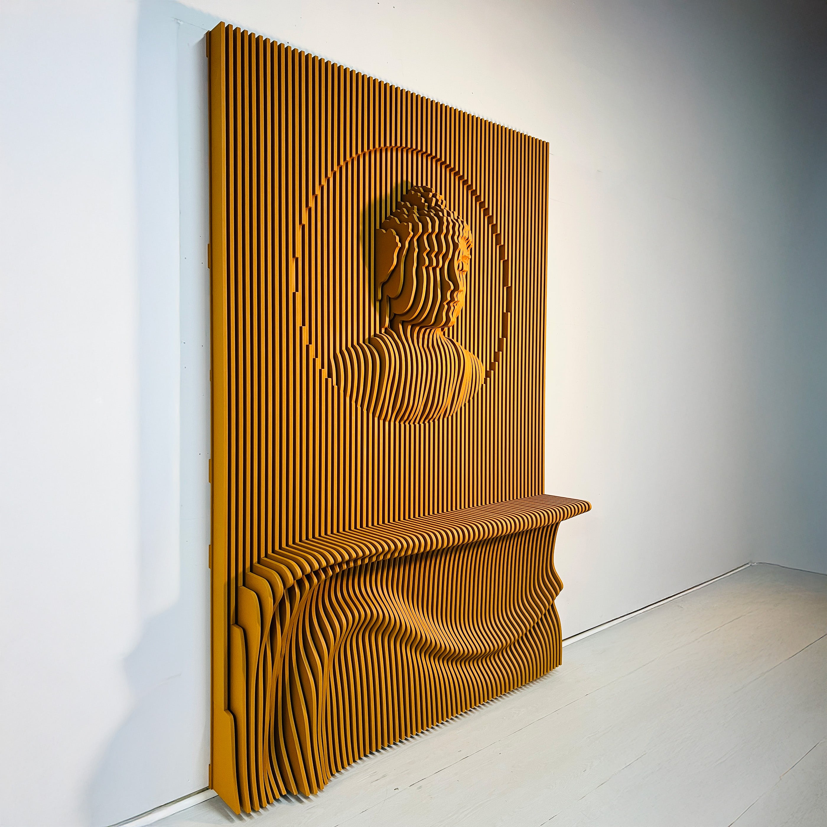 Wooden wall art with Buddha design on a white wall