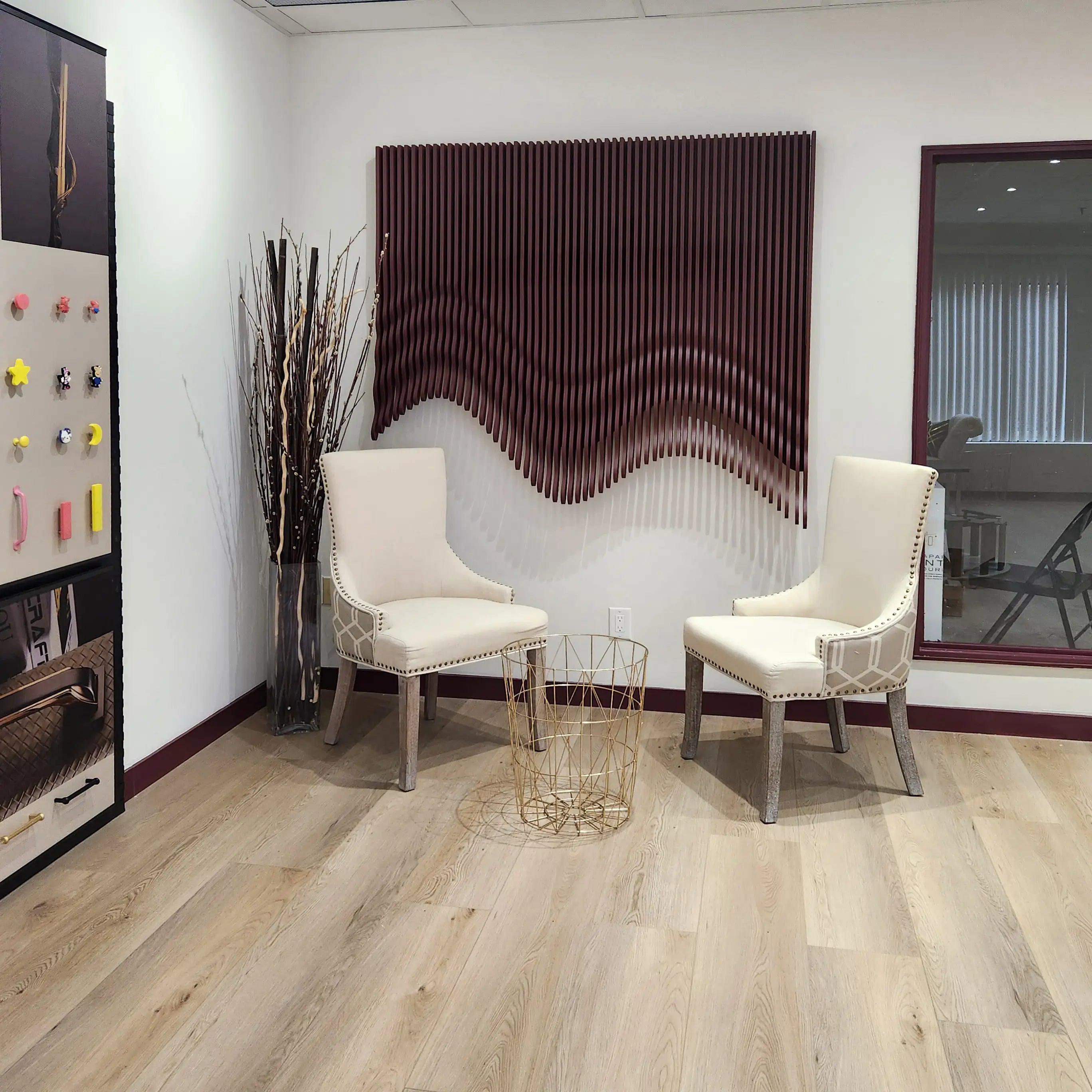 Modern interior with two white chairs, a small table, and decorative elements on a light wood floor.