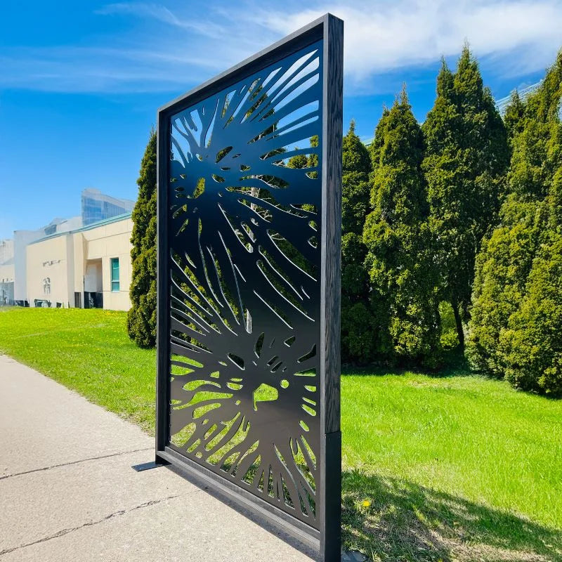 Decorative metal screen with leaf pattern on a grassy area