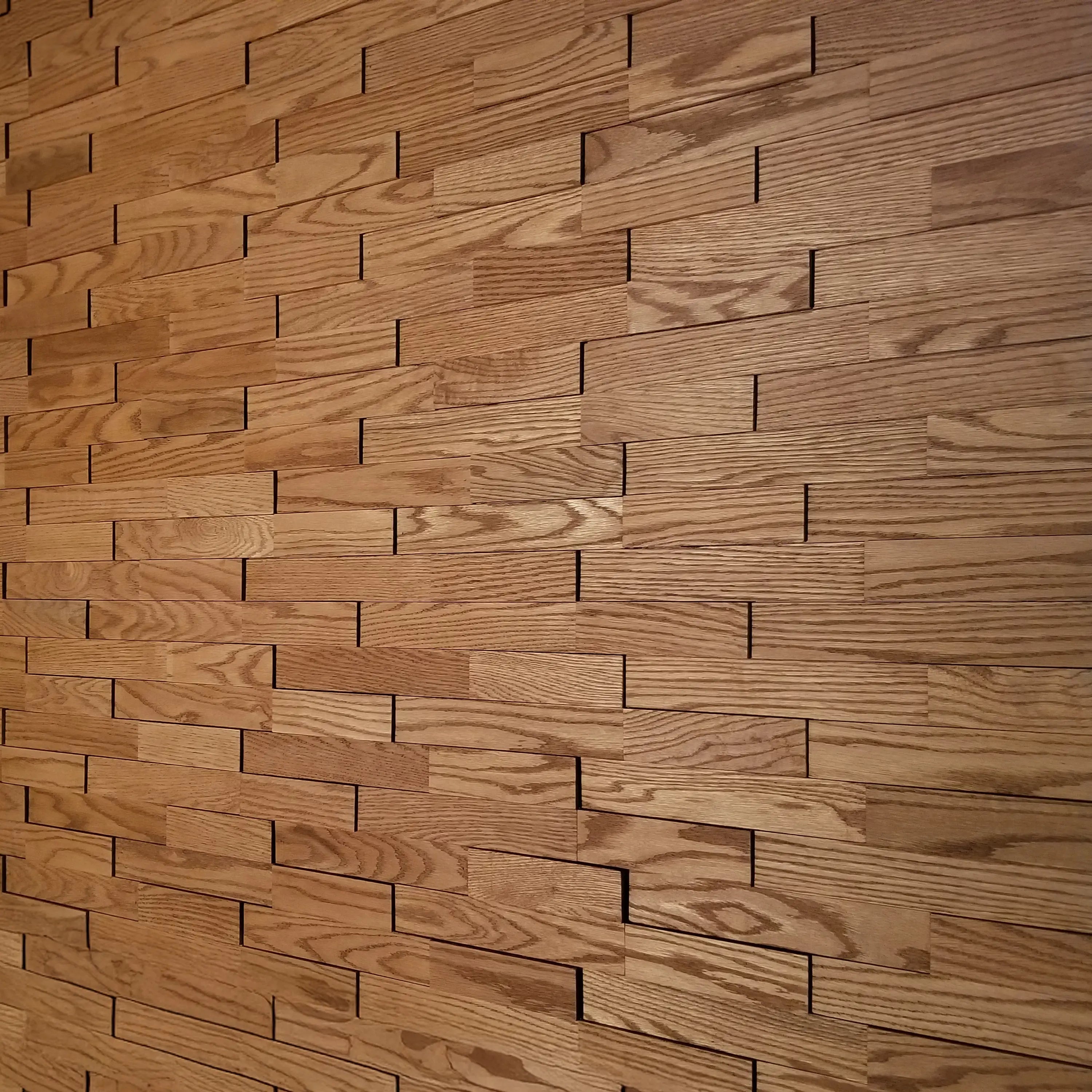 Patterned wooden wall paneling with a brick-like design.