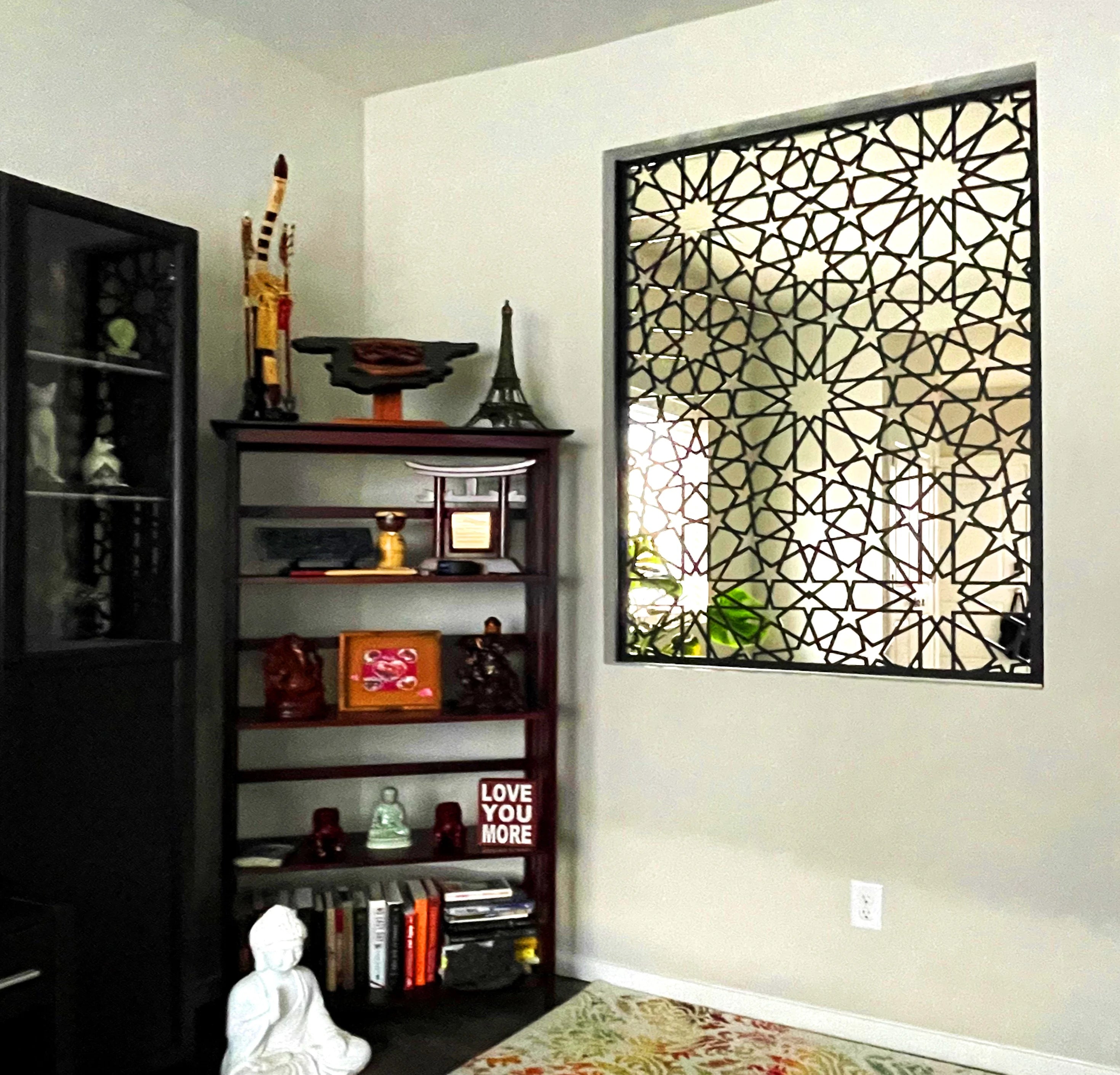 Decorative wall panel with geometric pattern in a room with shelves and decor items.