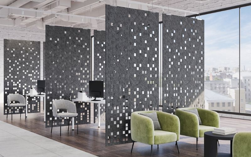 Modern office space with decorative wall panels and green chairs.