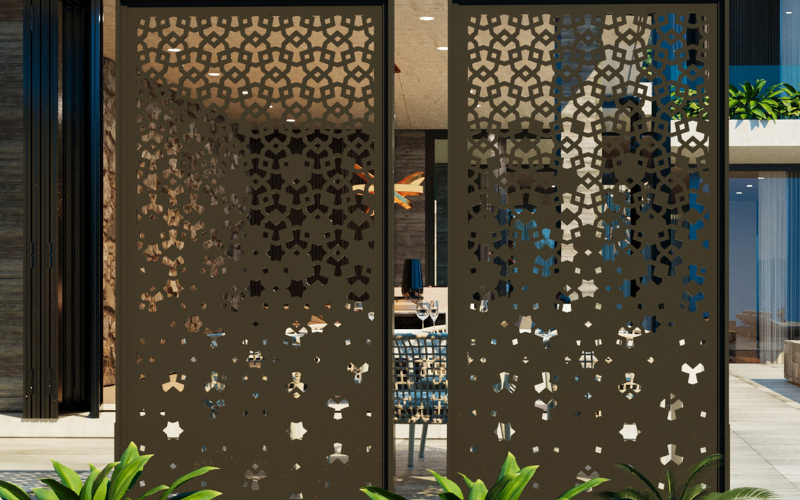 Decorative metal screen with intricate cut-out patterns in an outdoor setting.