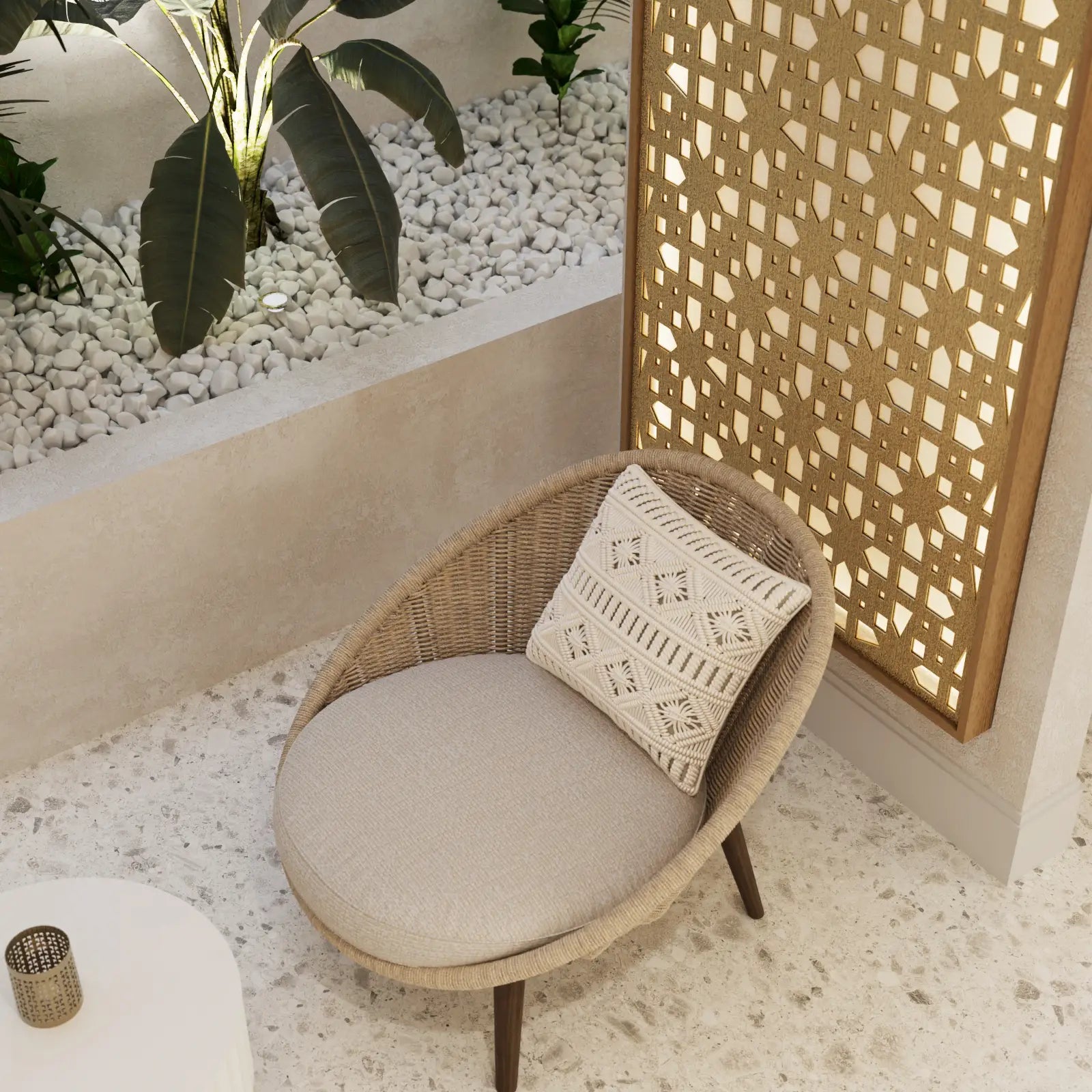 Wicker chair with a cushion and decorative pillow in a room with pebbles and plants.