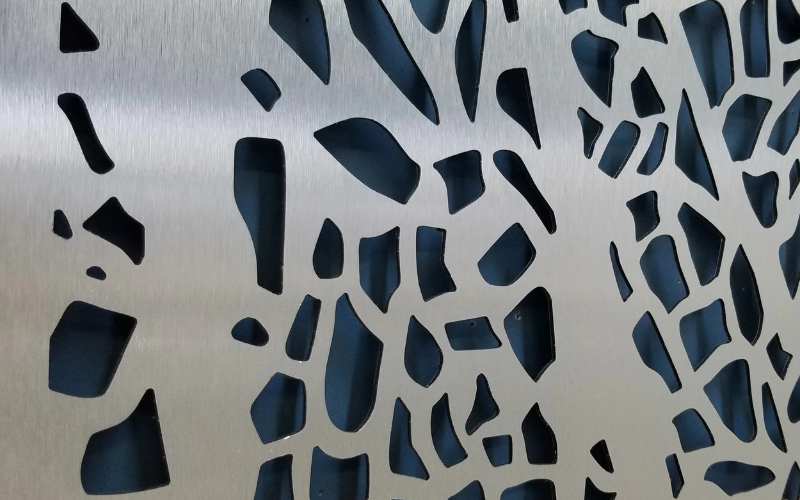 Metallic surface of privacy screen with a geometric cut-out pattern