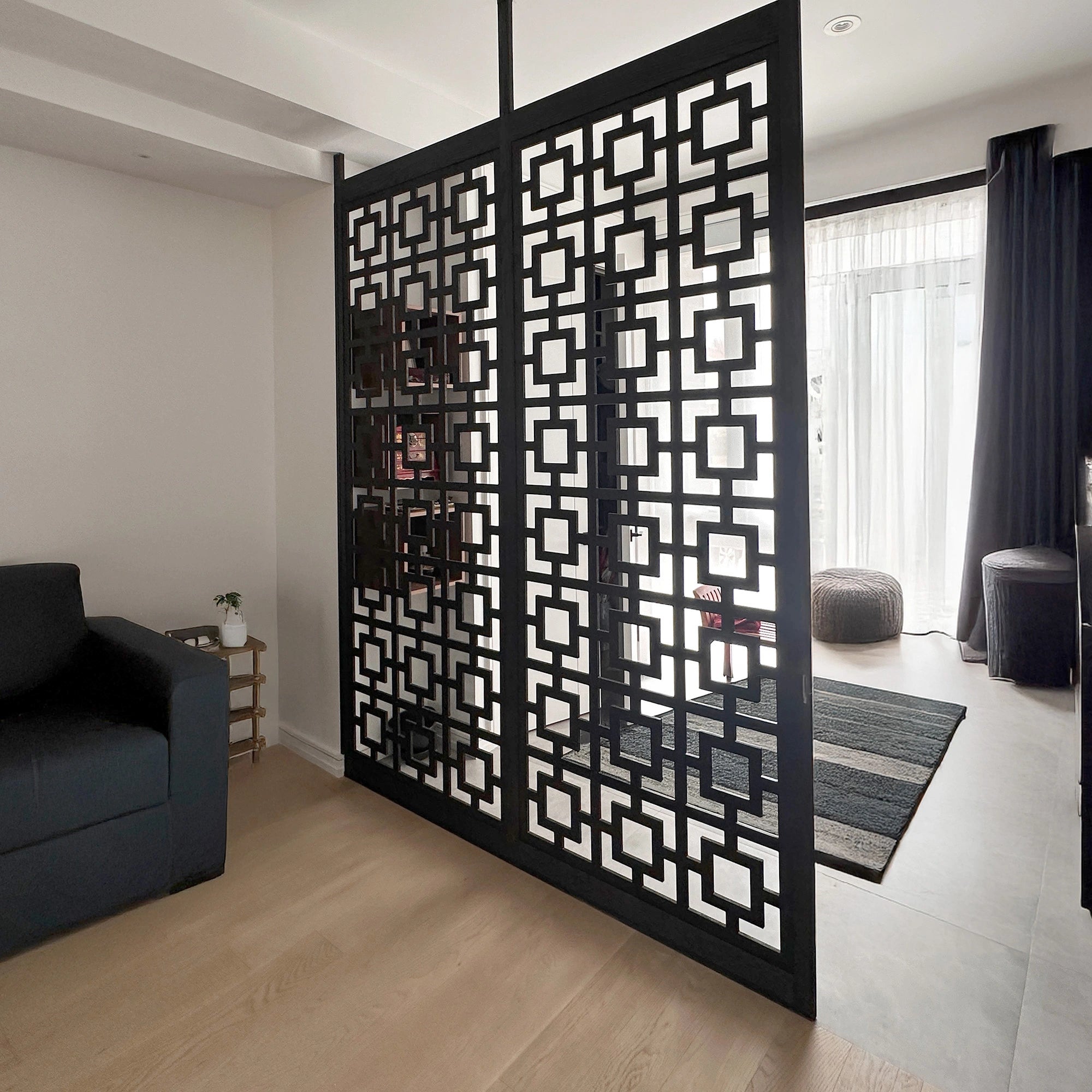 Decorative black screen with geometric pattern in a modern living room.