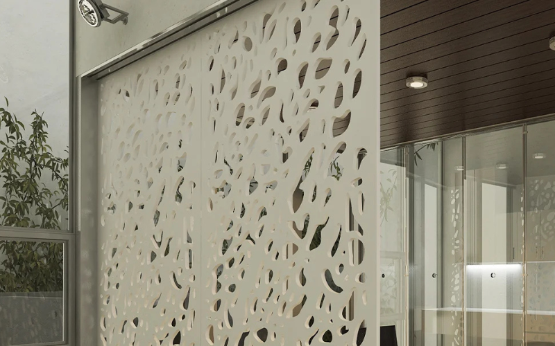 Decorative wall panel with cut-out patterns in an indoor setting