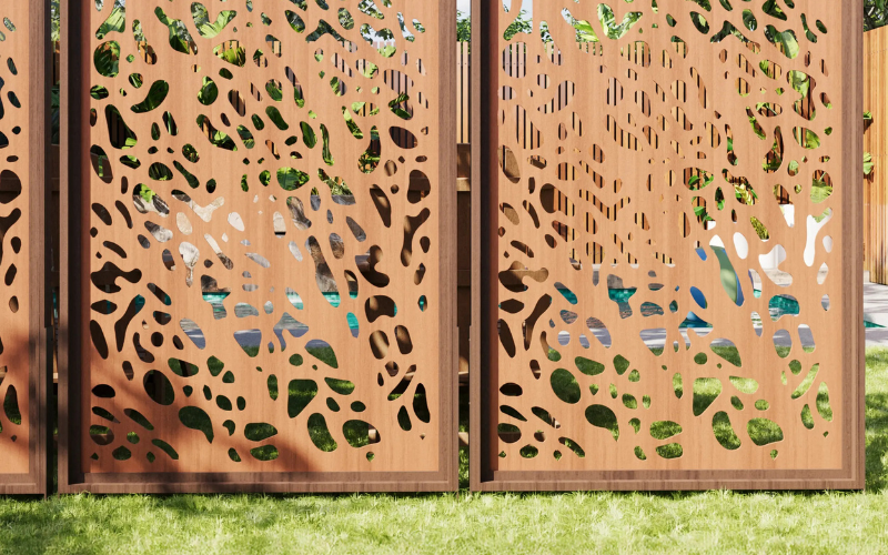 Decorative metal screen with cut-out patterns on a grassy background