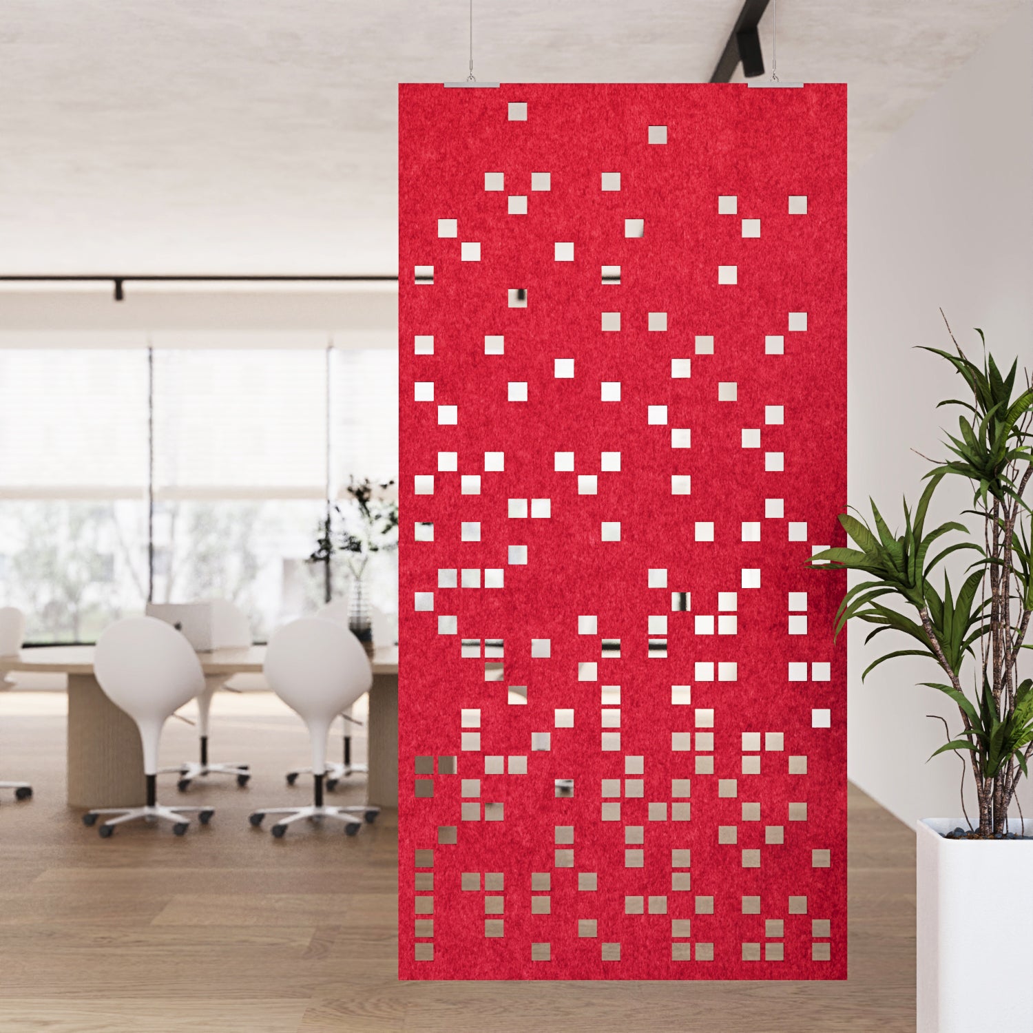 Red patterned room divider in an office setting with white chairs and a plant.