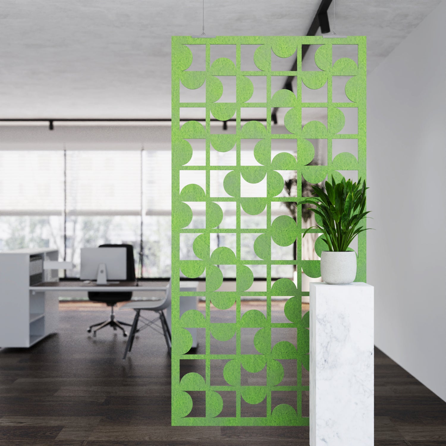 Decorative green screen panel in an office setting with a plant on a white pedestal.