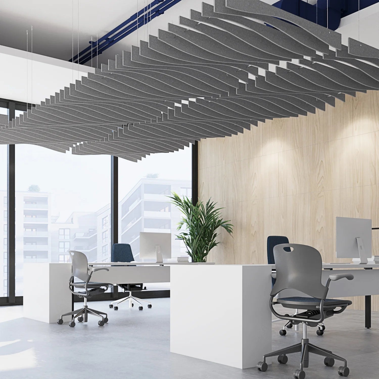 Modern office interior with desks, chairs, and large windows.