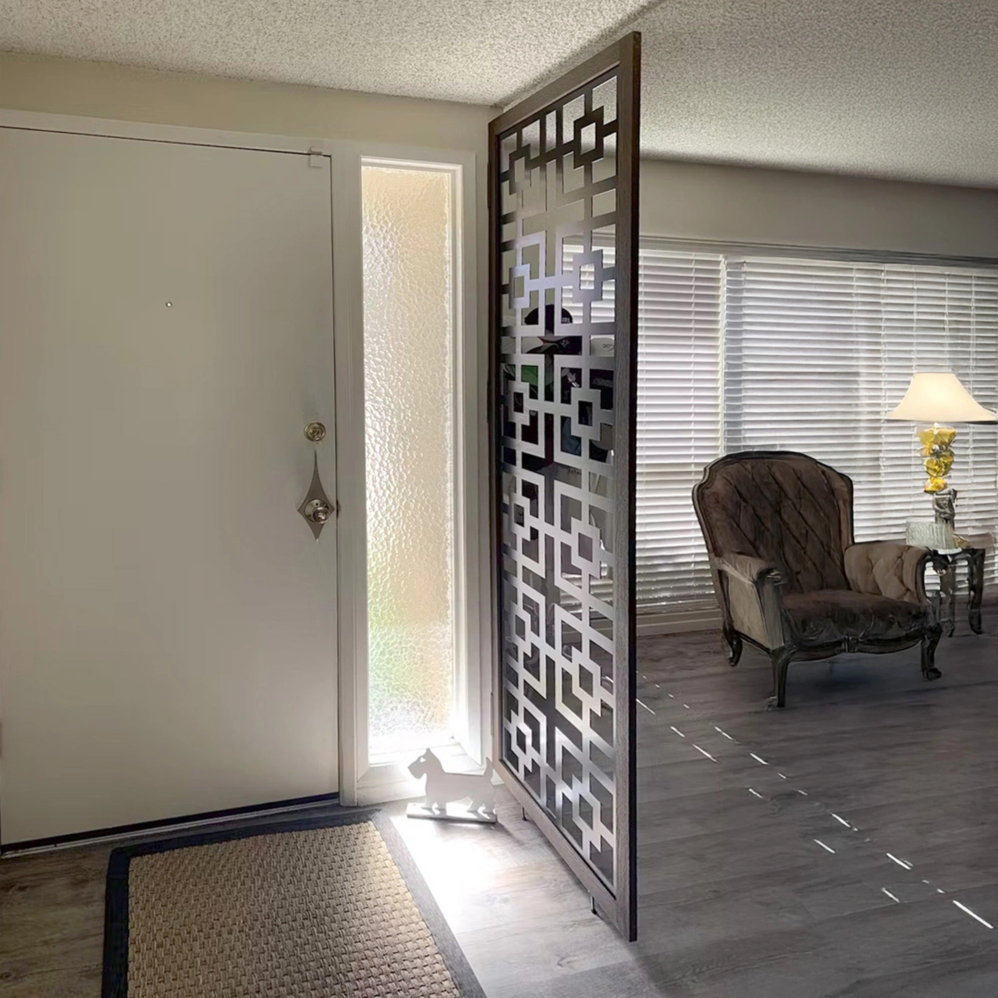 Decorative black acm privacy screen in a room with a chair and lamp