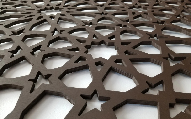 Decorative wooden panel with geometric cut-out pattern on a white background