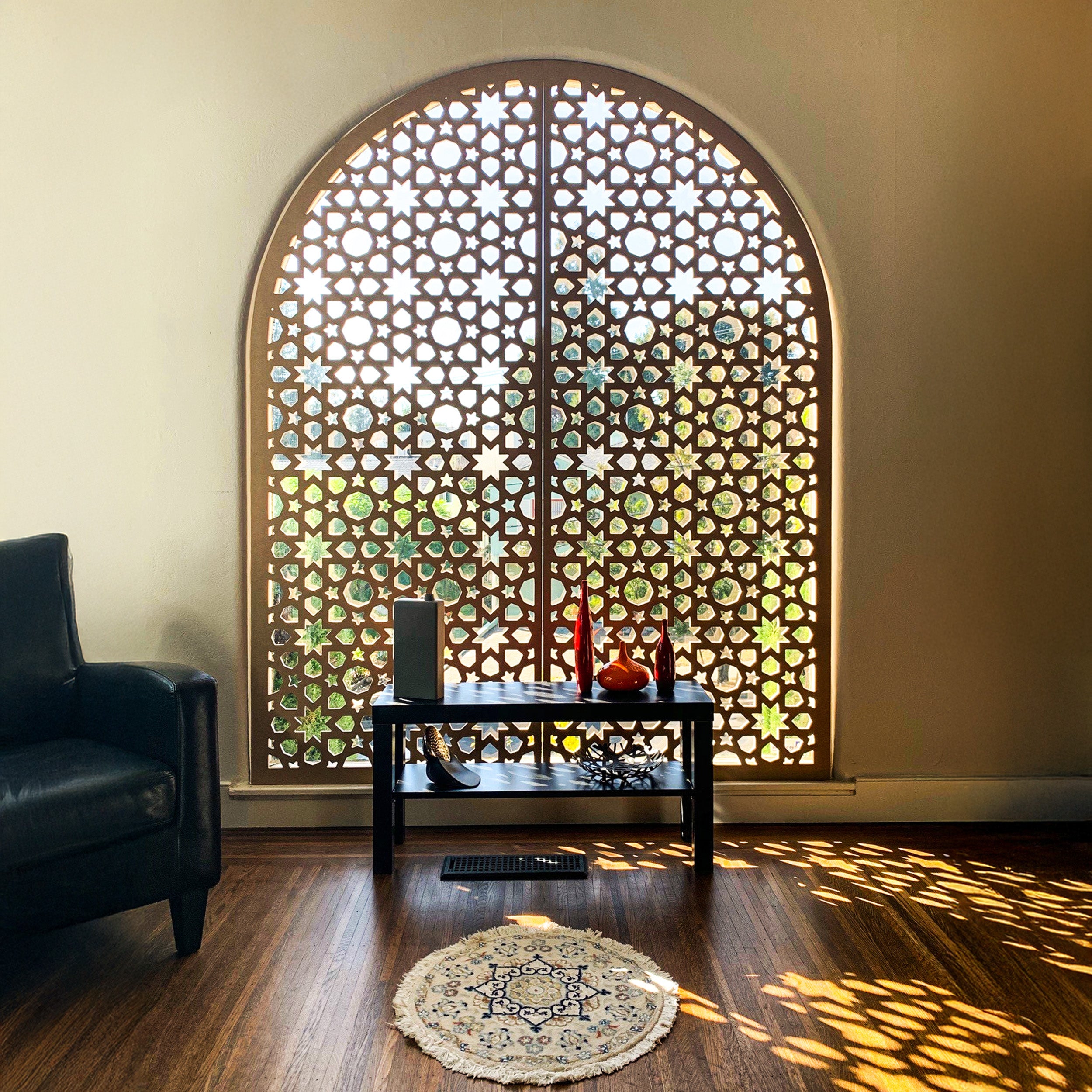 Decorative Moroccan style screen with geometric pattern in a room with a black chair and small table.