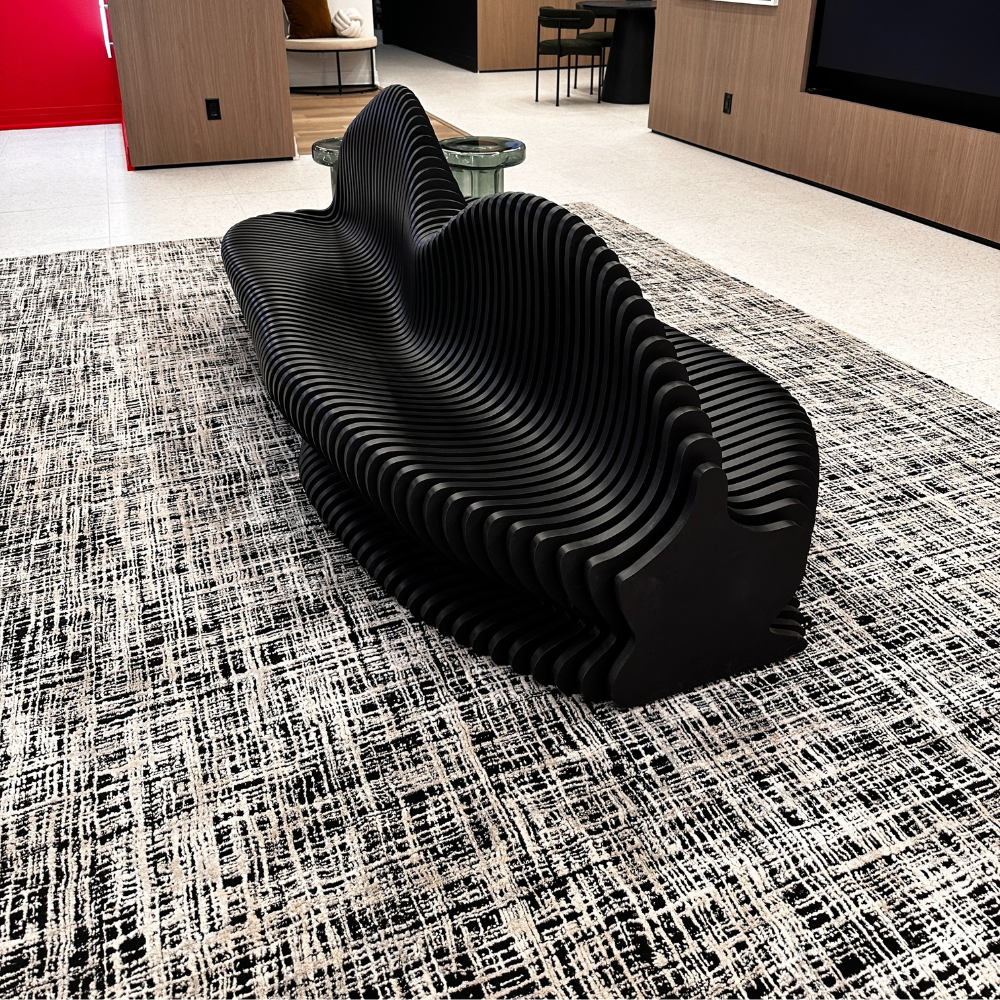 Modern black bench on a patterned rug in an indoor setting
