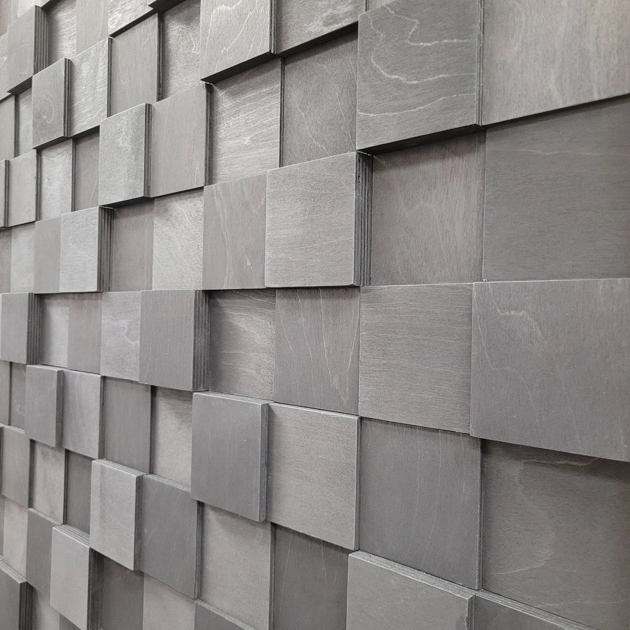Wall made of square gray tiles with varying shades