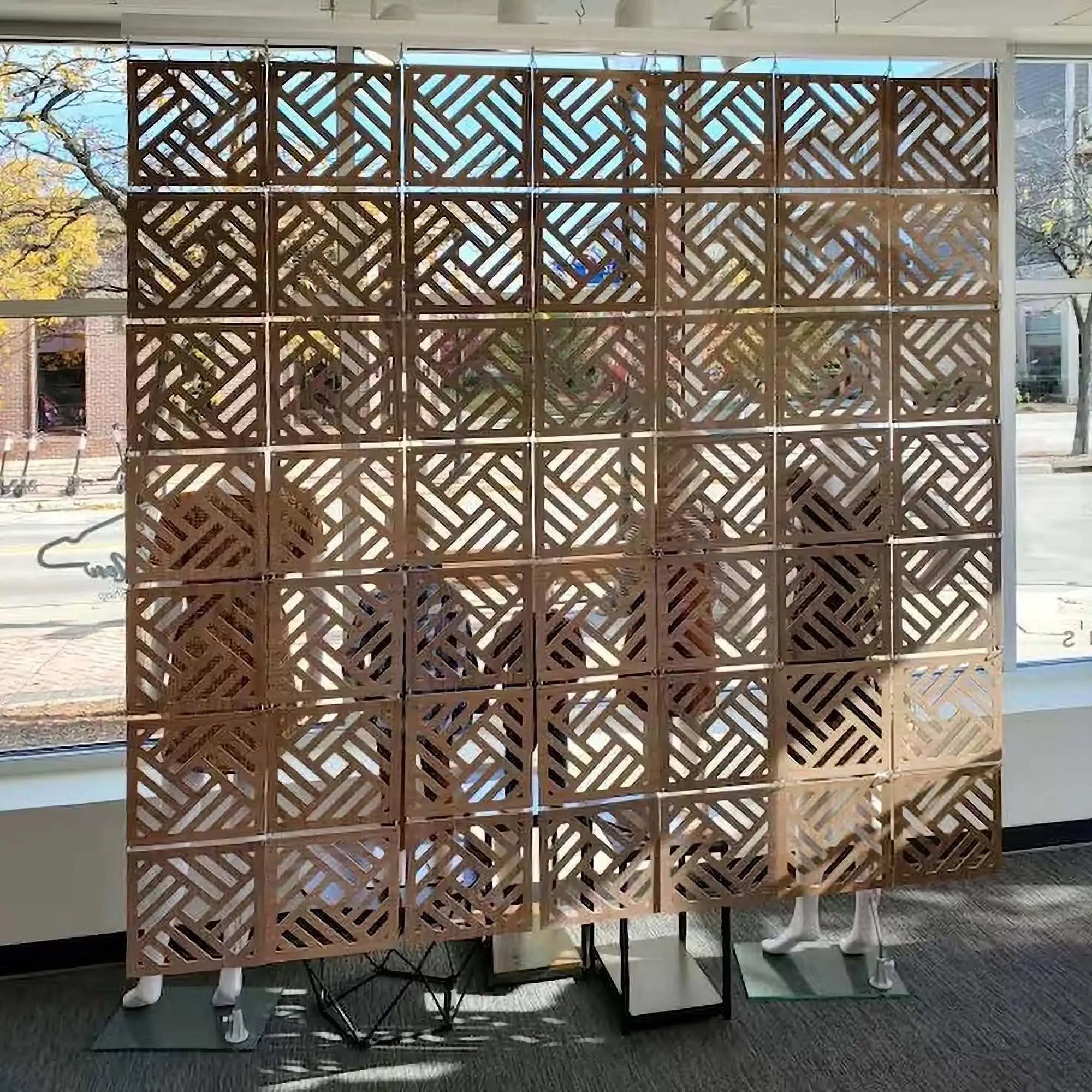 Decorative metal screen with geometric pattern in an indoor setting