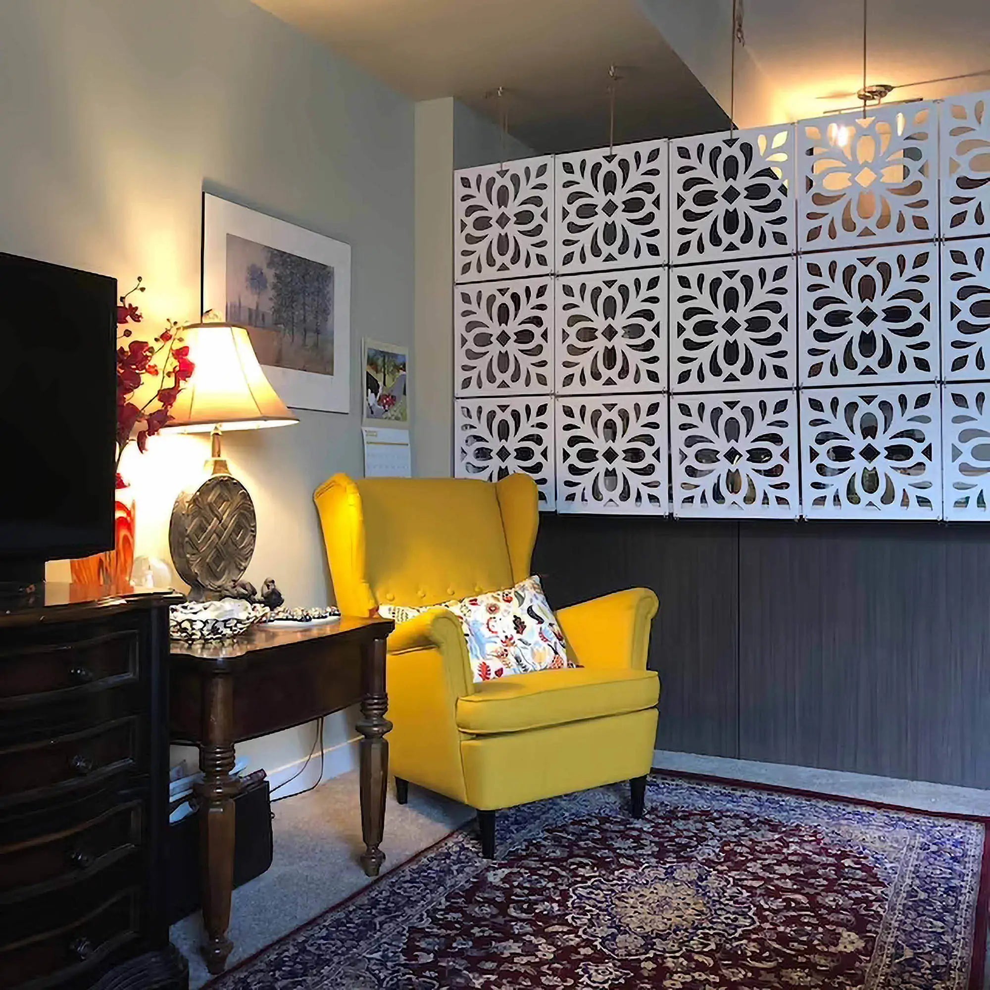 Living room with a yellow armchair, decorative wall panels, and a lamp.