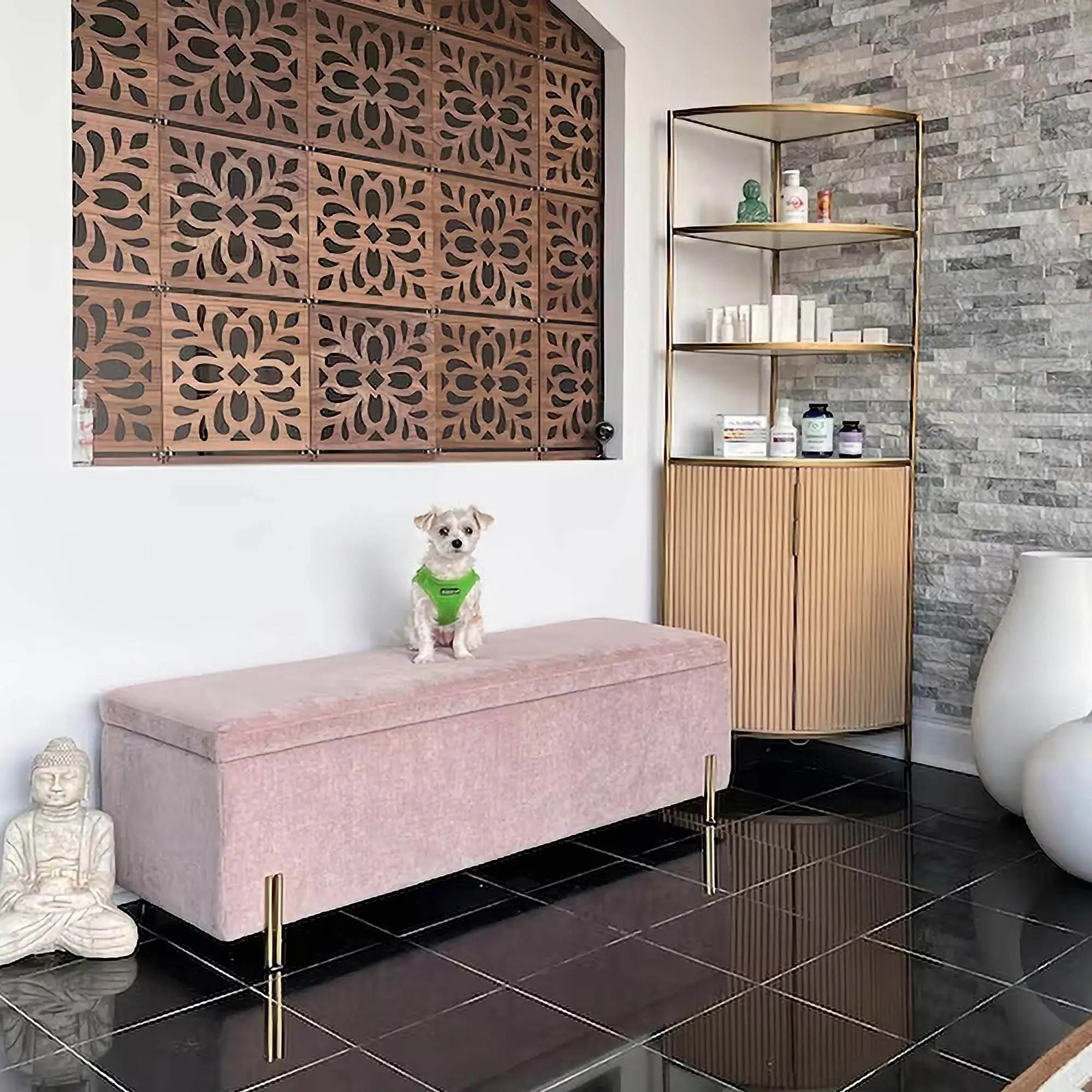 Dog on a pink ottoman in a stylish room with decorative wall panels and shelves.