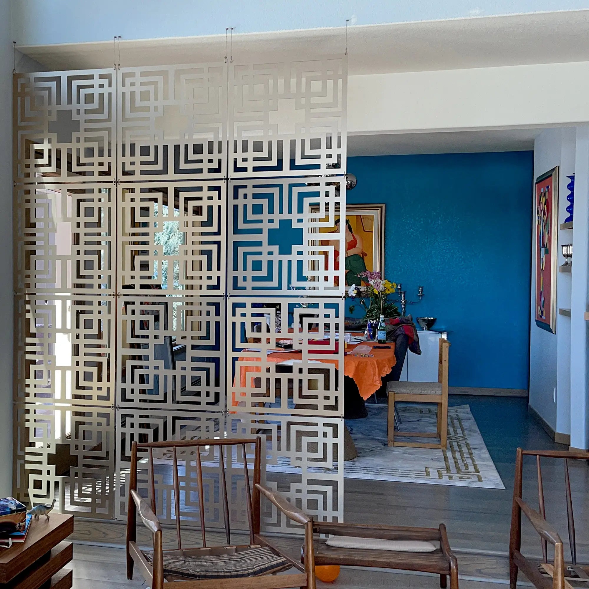 Decorative screen in a room with a dining table and chairs.