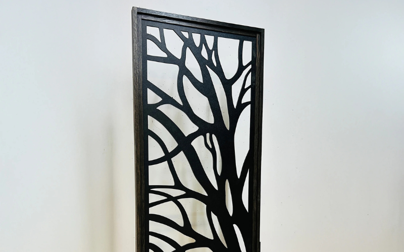 Decorative screen with tree branch pattern on a white wall