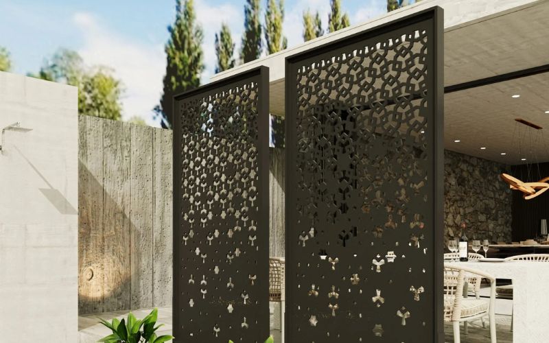 Decorative metal screen with cut-out patterns in an outdoor setting