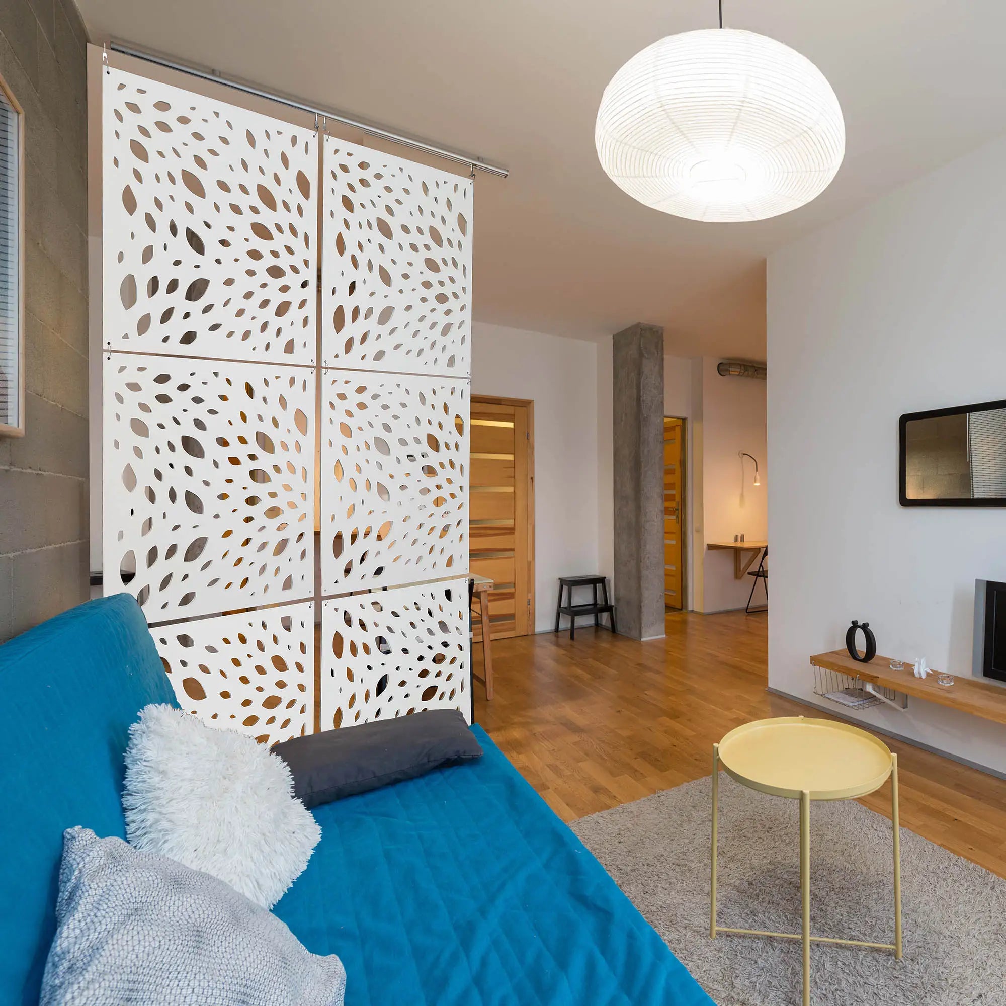 Modern living room with decorative wall paneling and a blue sofa.