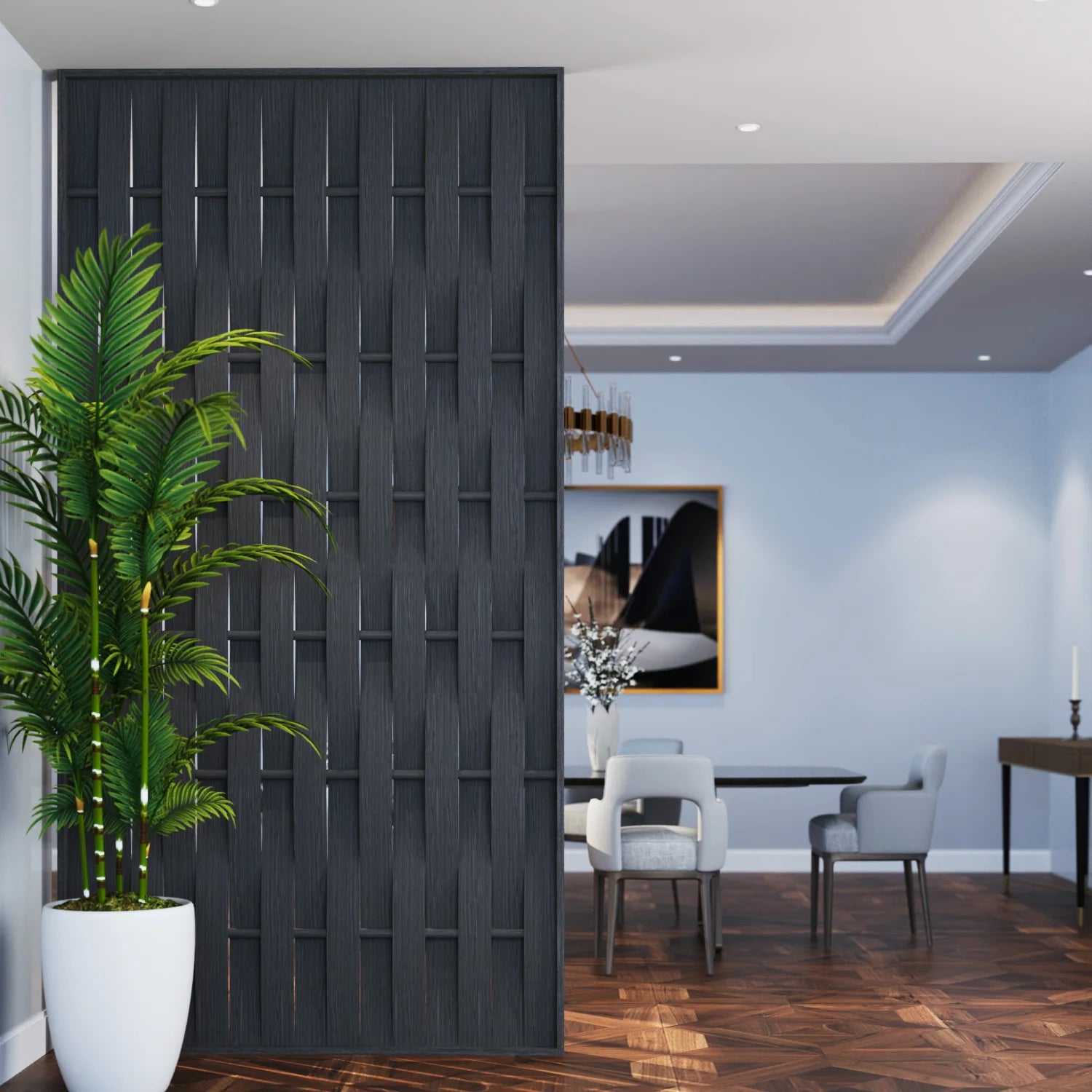 A modern interior scene with a tall dark charcoal gray wooden slatted partition screen in the foreground, next to a large potted green palm in a white planter. In the background, a dining area with light blue walls, gray chairs, and a dark wood herringbone floor is visible.