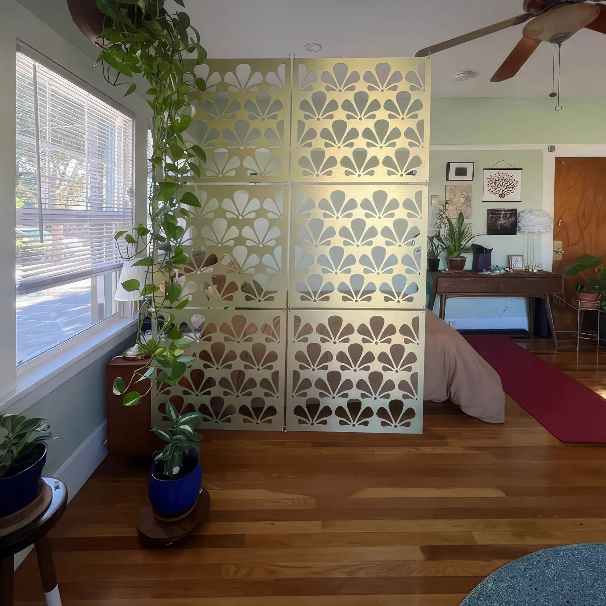 Decorative wall panel with floral pattern in a room with plants and furniture.