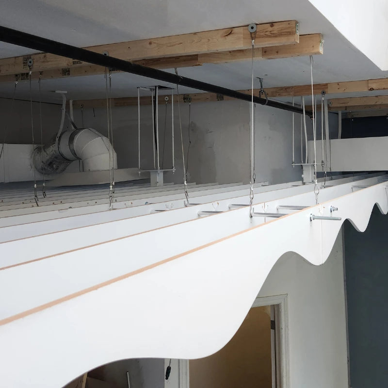 White awning attached to a building with wooden beams and a white wall in the background.