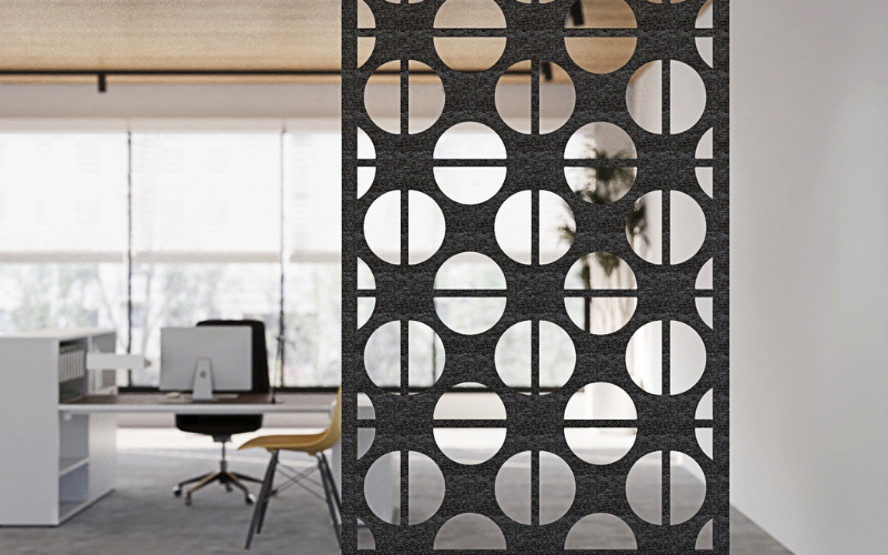 Decorative room divider with circular cutouts in an office setting